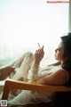 A woman sitting on a chair smoking a cigarette.