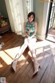 A woman sitting on a wooden floor in a room.