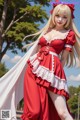 A woman in a red and white dress is posing for a picture.