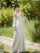A woman in a white dress standing in a garden.
