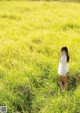 A woman standing in a field of tall grass.